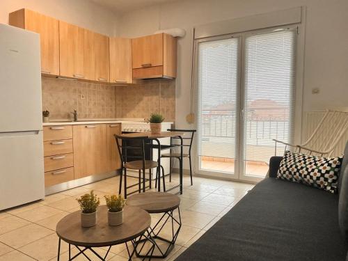 eine Küche mit einem Sofa und einem Tisch mit Stühlen in der Unterkunft MaVitaPlace Harmonia Apartment in Kateríni