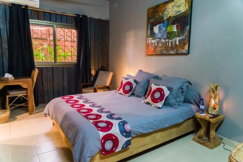 a bedroom with a large bed with red pillows at Nomads in Lomé