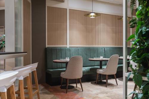 a dining room with two tables and chairs at Hilton Garden Inn Bologna North in Bologna