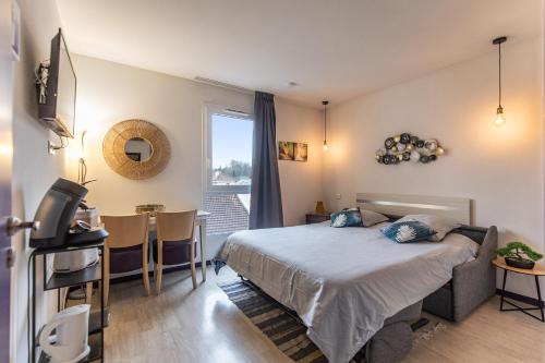 une chambre avec un lit, une table et une fenêtre dans l'établissement Tithome 2 - Gare, centre ville, vue montagne et château, à Lourdes