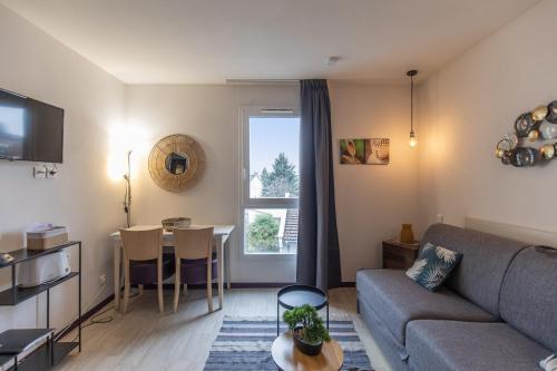 un salon avec un canapé et une table dans l'établissement Tithome 2 - Gare, centre ville, vue montagne et château, à Lourdes