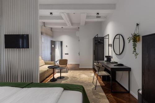 a bedroom with a bed and a desk and a couch at Konventa Sēta Hotel Keystone Collection in Rīga