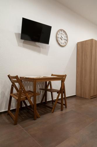 a table with a chair and a clock on a wall at suite 18 luxury apartments in Bari