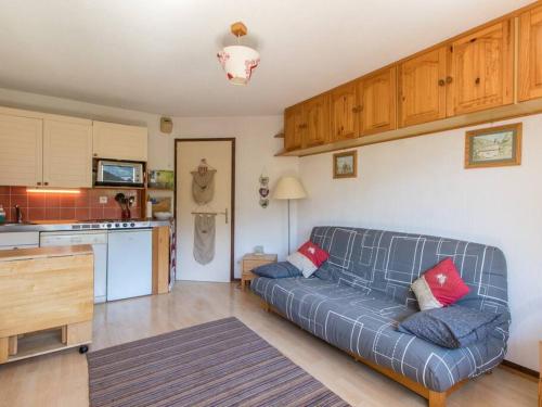 un salon avec un canapé et une cuisine dans l'établissement Appartement cœur de village, à Samoëns