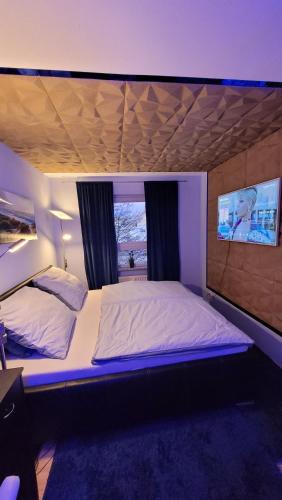 ein Schlafzimmer mit einem großen Bett mit violetter Beleuchtung in der Unterkunft Unique Munich Apartment in Unterhaching