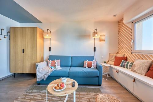 sala de estar con sofá azul y mesa en Résidence Pierre & Vacances Les Tamaris, en Trouville-sur-Mer