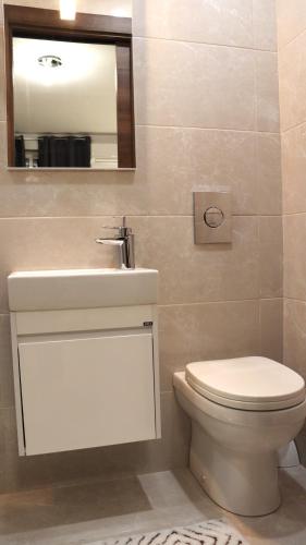 łazienka z toaletą, umywalką i lustrem w obiekcie SC6 - Modern & Spacious 2 Bed w mieście St Paul's Bay