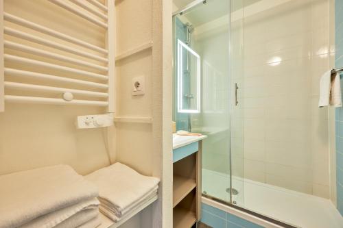 uma pequena casa de banho com um chuveiro e um lavatório. em Résidence Pierre & Vacances Les Tamaris em Trouville-sur-Mer