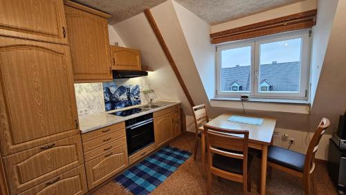 cocina con mesa y cocina pequeña con ventana en Bei München Ferienwohnung Mahr in Kottgeisering "Mahr", en Kottgeisering