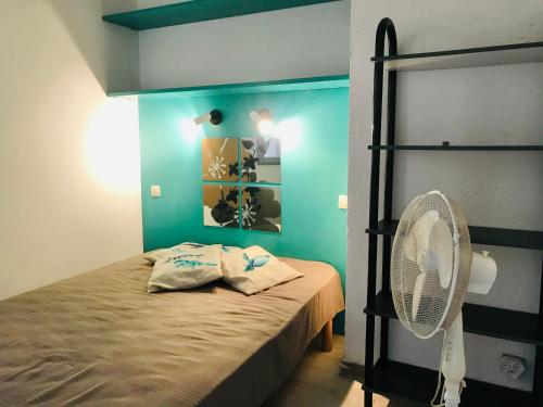 - une chambre avec un lit et un ventilateur dans l'établissement Appartement PORTO 35 Lumio, à Lumio