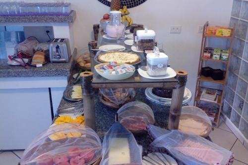 a kitchen with a table with food on it at Pousada Irashai in Juquei