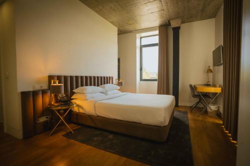 een slaapkamer met een groot bed en een raam bij Borralha Hotel, Restaurante & Spa in Vila Real