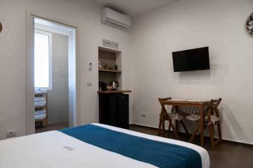 a bedroom with a bed and a table and a television at suite 18 luxury apartments in Bari