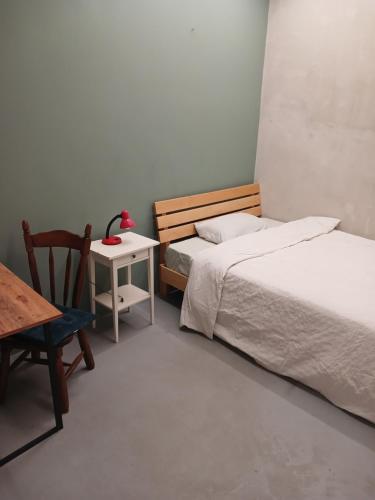 1 dormitorio con 2 camas, mesa y silla en Shared flat in an artists district Pikris Gora en Tiflis