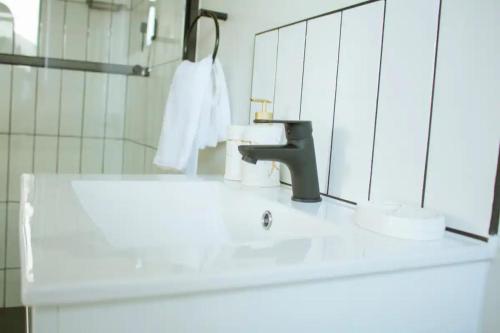 a bathroom sink with a faucet and a mirror at Lifestyle apartment in Sandton - Urban39 in Sandown