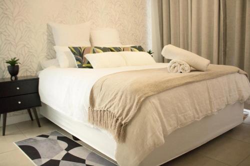a bedroom with a large bed with white sheets and pillows at Lifestyle apartment in Sandton - Urban39 in Sandown