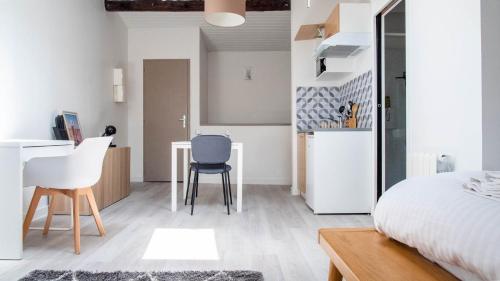 - une chambre avec un lit, une table et des chaises dans l'établissement Chez Thomas - Bel appartement à Poitiers !, à Poitiers