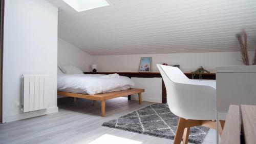 una camera con letto, scrivania e sedia di Chez Thomas - Bel appartement à Poitiers ! a Poitiers