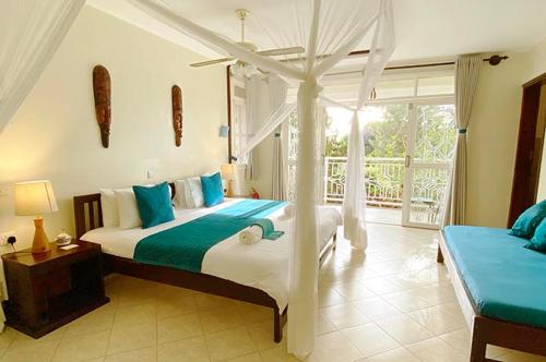 a bedroom with a bed with a canopy at Karibu Entebbe in Entebbe