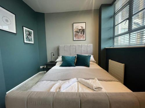 - une chambre avec un grand lit aux murs bleus dans l'établissement Entire Stylish Apartment Central Brighton North St, à Brighton et Hove