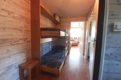 Ce lit superposé se trouve dans un dortoir doté d'un mur en bois. dans l'établissement Le nid de Chamechaude, à Saint-Pierre-de-Chartreuse