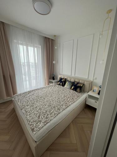 a large bed in a room with a large window at Apartament Vulcano Komfort Nowy Ursus in Warsaw