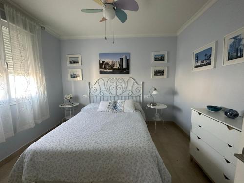 a bedroom with a white bed and a ceiling fan at Casa de diseño con jardín cerca de Córdoba in San Sebastián de los Ballesteros