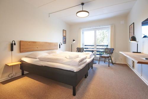 a bedroom with a large bed and a table at Motel Apartments in Tønder