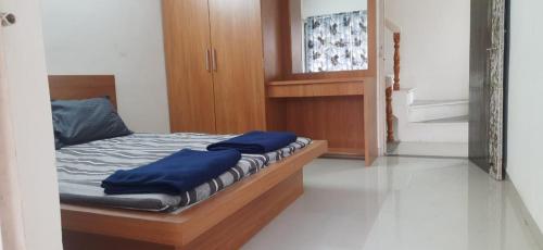a bedroom with a bed with blue pillows on it at Sojourns Homestay 2BHK in Kolhapur