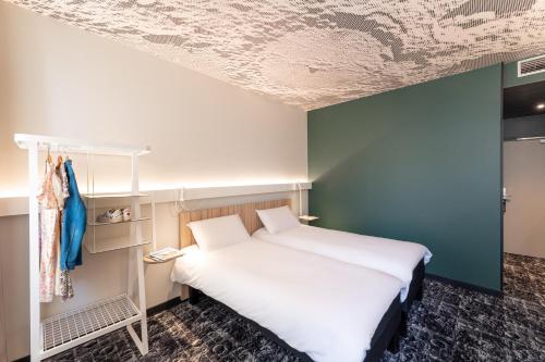 a bedroom with a white bed and a blue wall at ibis Lyon Centre Perrache in Lyon