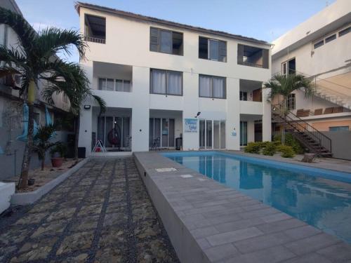 a building with a swimming pool in front of a building at Emira Poolside 3 bedroom family villa in Bain Boeuf