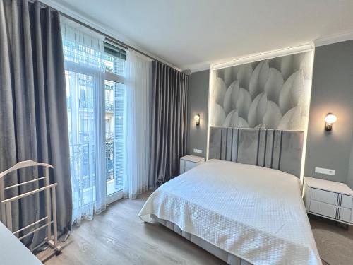een slaapkamer met een bed en een groot raam bij LUXE PALAIS DE LA MÉDITERRANÉE in Nice