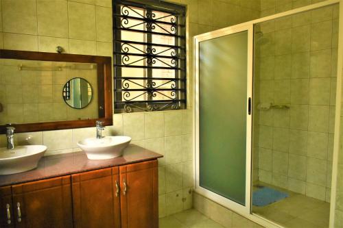a bathroom with two sinks and a shower at Ezeife Guesthouse in Kampala