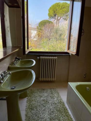 a bathroom with two sinks and a window at Villa Rosi in Lierna