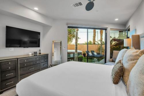 1 dormitorio con 1 cama grande y TV en Villa Callejon Del Sol Permit# 3082 en Palm Springs