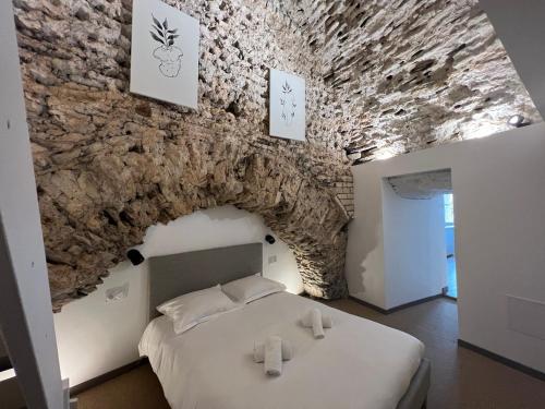 Bett in einem Zimmer mit einer Steinmauer in der Unterkunft Les Arches - Superbe appartement en centre-ville in Poitiers