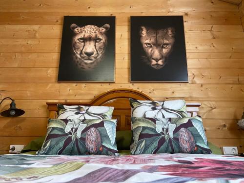uma cama com duas fotos de leões na parede em FINCA ALMAZARA em San Pablo