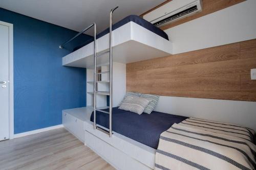 a bedroom with a bunk bed and blue walls at Beach Living, apart. duplex, o melhor da região. in Aquiraz