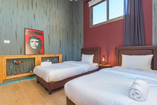 two beds in a room with red walls at 961 Station Apartments in Mar Mikhael in Beirut