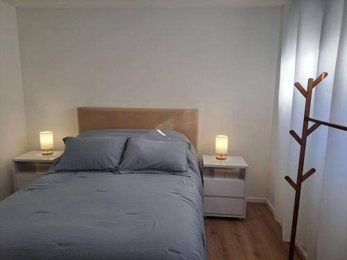 1 dormitorio con 2 mesitas de noche con 1 cama y 2 lámparas en Nuevo, apartamento completo, opción parking, en Cordón Soho, en Montevideo