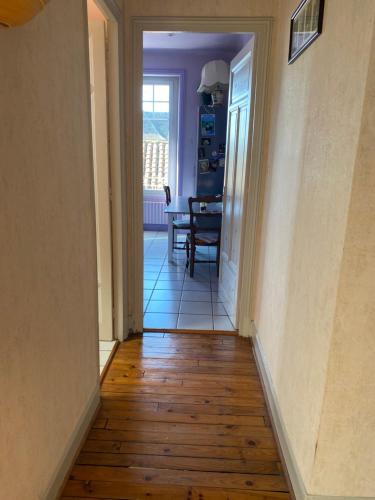 a hallway with a dining room and a table at Les chambres de Marielou in Aurillac