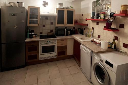 une cuisine avec un réfrigérateur et une machine à laver dans l'établissement Appartement T2 Ajaccio vieille ville, à Ajaccio