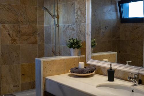 Un baño con lavabo, ducha y espejo. en Villa Mo Luxury Heated Pool, en Playa Blanca