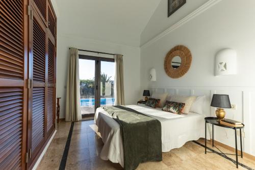 Un dormitorio con una cama y una ventana grande en Villa Mo Luxury Heated Pool, en Playa Blanca