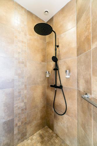 une douche avec pommeau de douche dans une salle de bain dans l'établissement Villa Évasion Charme et Détente, à Maraussan