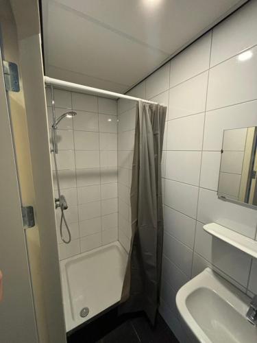 een badkamer met een douche en een wastafel bij Hermanos City Appartement in Enschede
