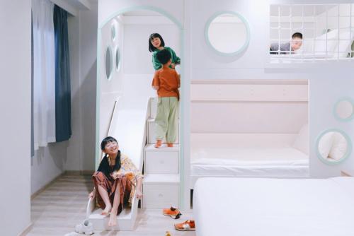 two girls sitting on the stairs of a bunk bed at Rest Bugis Hotel in Singapore