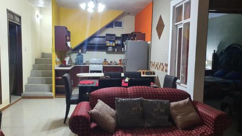ein Wohnzimmer mit einem Sofa und einer Küche in der Unterkunft LA OFFI GT in Huehuetenango