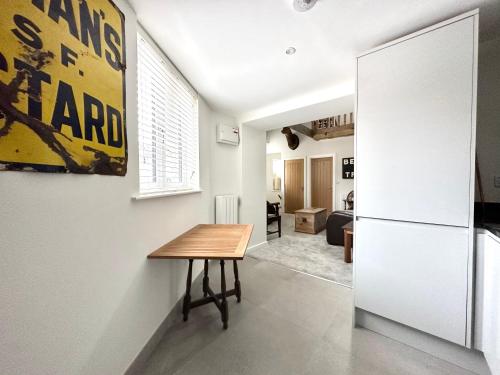 a kitchen with a table and a refrigerator at Apartment in Midsomer Norton High St in Midsomer Norton