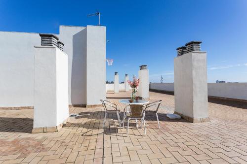 a table and chairs on a patio with pillars at LuxSevilla Piscina Parking Gratis in Bormujos